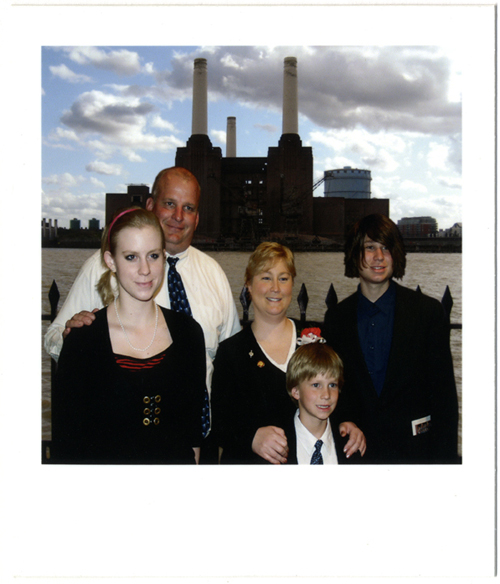 Young boy wearing a doily on his head infront of Battersea Power Station